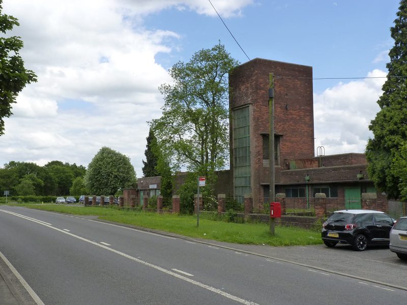 A long low brick pithead baths building with banded brickwork and a row of high windows, standing beside Coleshill Road at Ansley.