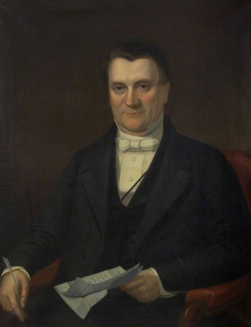 An oil portrait of a seated middle-aged man in a black coat, pale waistcoat and white bow tie, holding a folded letter and a quill, against a dark ground.