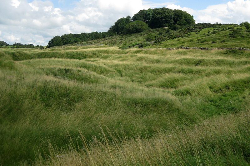 A wide view east over the disturbed ground of the Charterhouse lead workings under an open Mendip sky