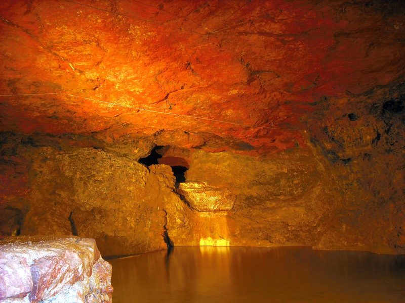 A still, dark subterranean lake beneath the natural cave roof at Clearwell Caves.