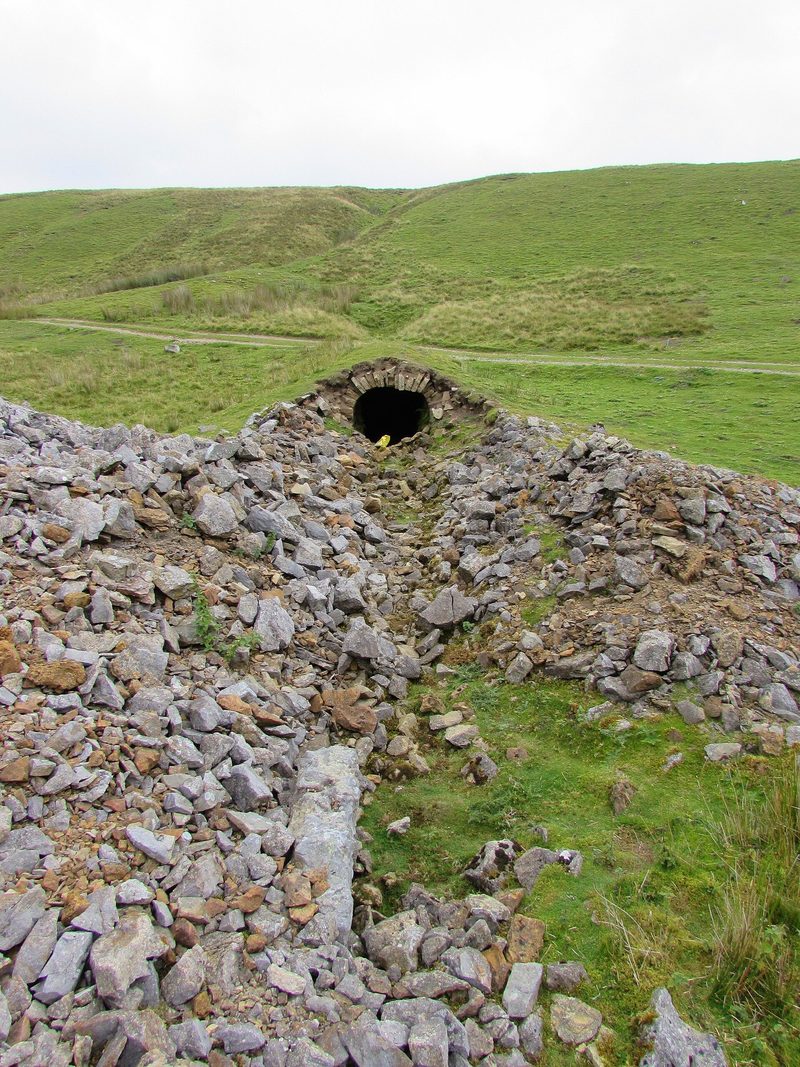 The stone-arched mouth of one of the four levels at Faggergill lead mine, set in rough moorland above Arkengarthdale.