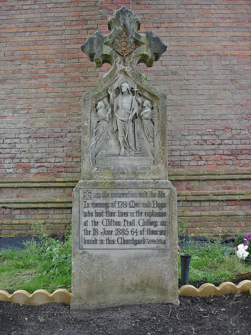 A stone memorial in a churchyard to the men and boys killed in the Clifton Hall colliery explosion of 1885