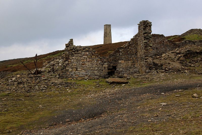 The roofless stone walls of the Cobscar lead smelting mill standing in rough pasture on the moor above Redmire.