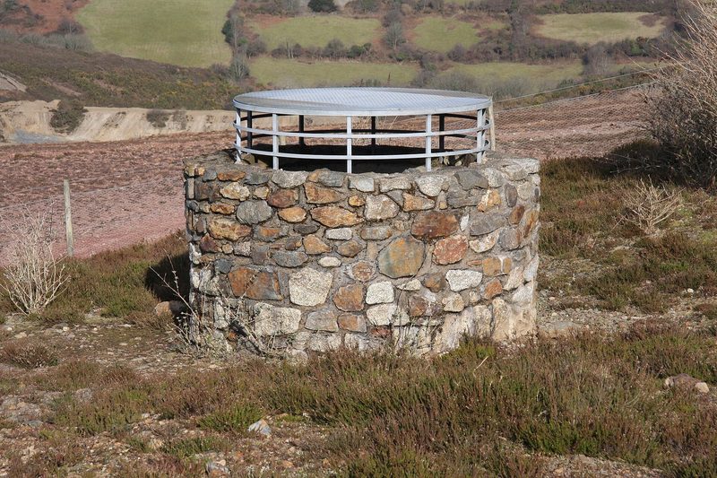A capped mine shaft covered with a steel grille in rough ground in the Wheal Maid Valley, on the ground of one of the mines amalgamated into Consolidated in 1782.
