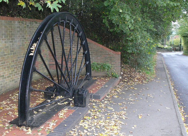 A section of a colliery winding wheel set up as a memorial in parkland.