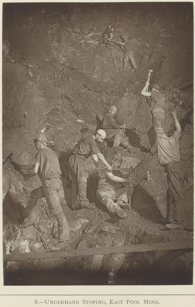 Miners working an underhand stope at East Pool by hand, photographed underground by flash-light around 1893.