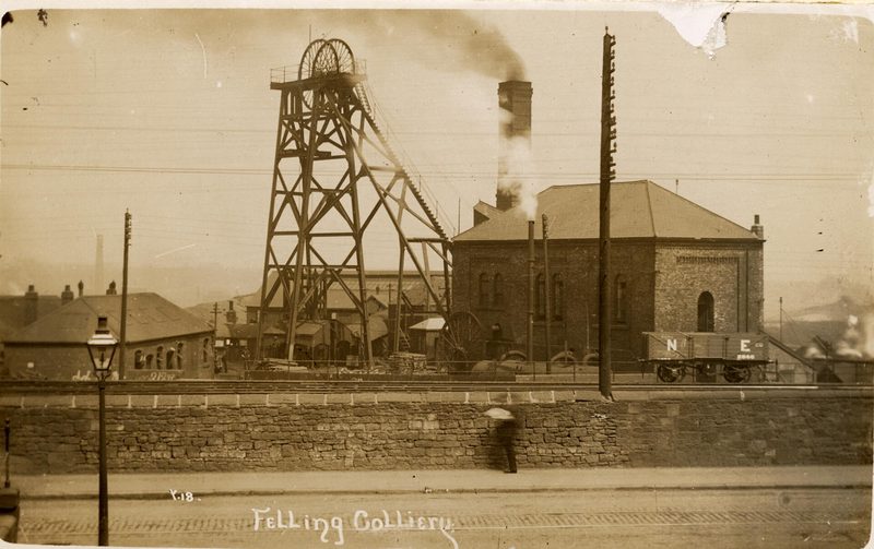 A squat brick round tower with a conical cap standing on grass, the surviving air shaft structure of John Pit at Felling Colliery.