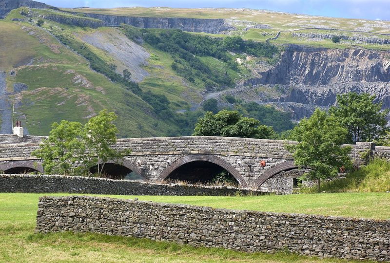 The pale scar of Foredale limestone quarry high on the hillside above Helwith Bridge, seen across the floor of Ribblesdale.