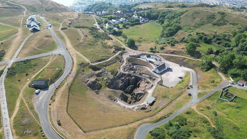 The excavated opencast copper workings on the Great Orme headland, pale limestone cut into terraces and trenches, photographed in June 2023.