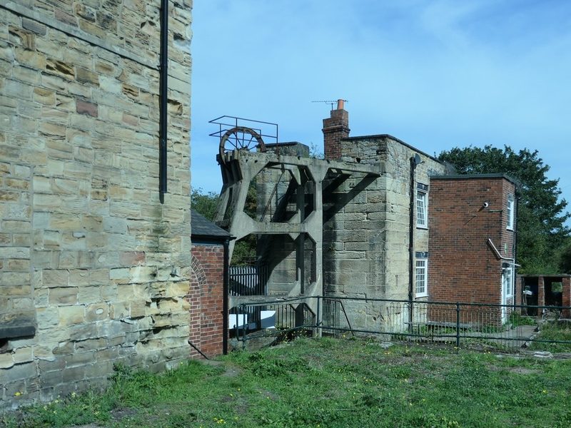 The stone winding engine house in the foreground and the Cornish pumping engine house beyond, with the 1934 concrete headframe between them, 2019