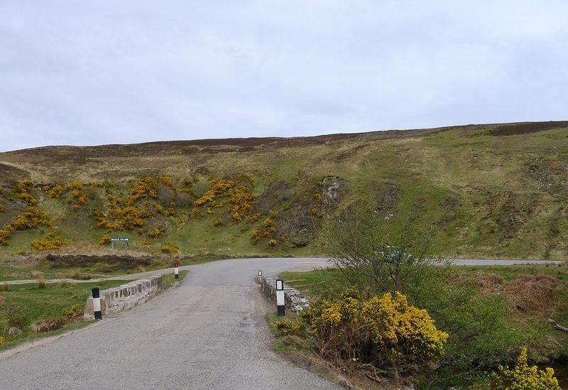 The open moorland site of Baile an Or beside the Kildonan Burn, with an interpretation sign where the prospectors' huts stood