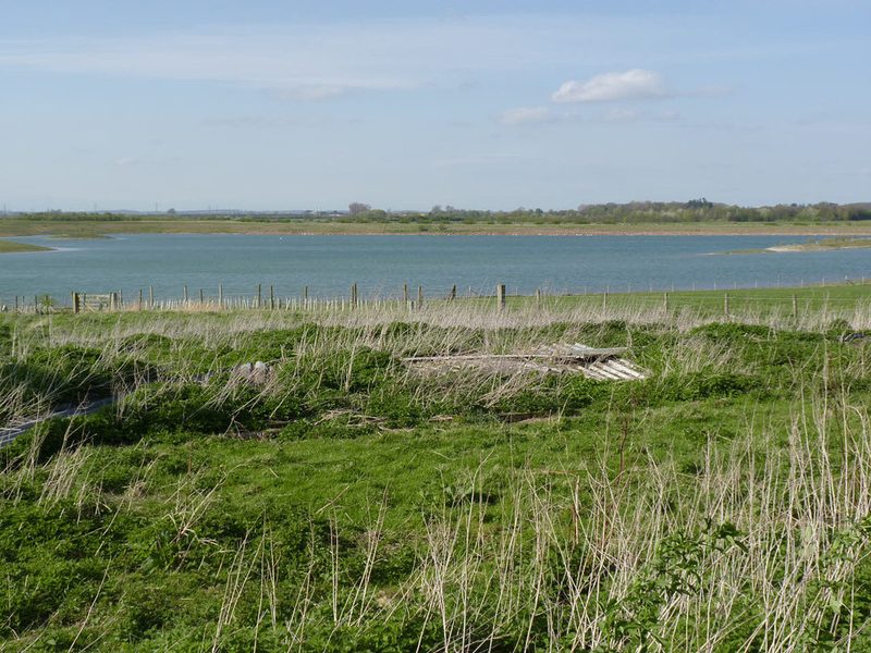 Flooded former opencast gypsum workings, now open water fringed with rough grass and scrub.