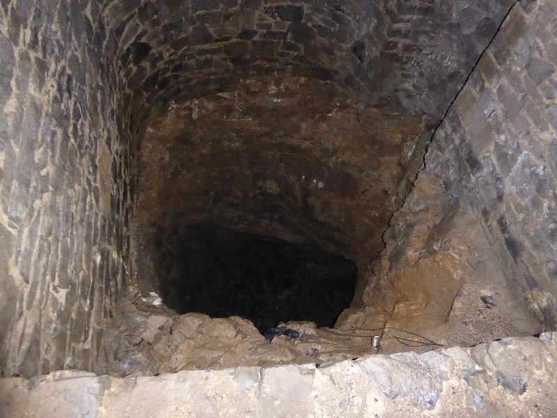 The open shaft beneath Bateman's House in Lathkill Dale, seen from inside the ruin.