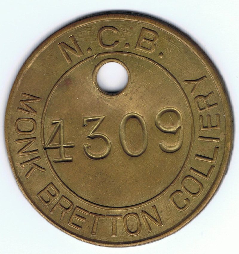 A round brass pit check stamped N.C.B. Monk Bretton Colliery with the number 4309