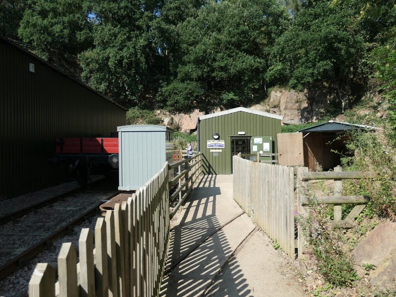 A modern exhibition building standing on the floor of the former Nunckley granite quarry, with the old quarry faces and trees rising behind it.