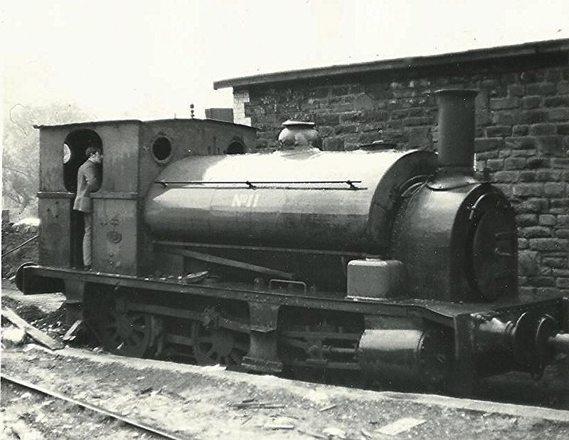 A green industrial saddle tank locomotive, Avonside works number 1421 of 1900 running as National Coal Board number 11, standing on colliery track.