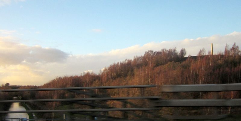 Open reclaimed ground and young woodland at Pooley Country Park on the former colliery site at Polesworth, with the valley beyond.