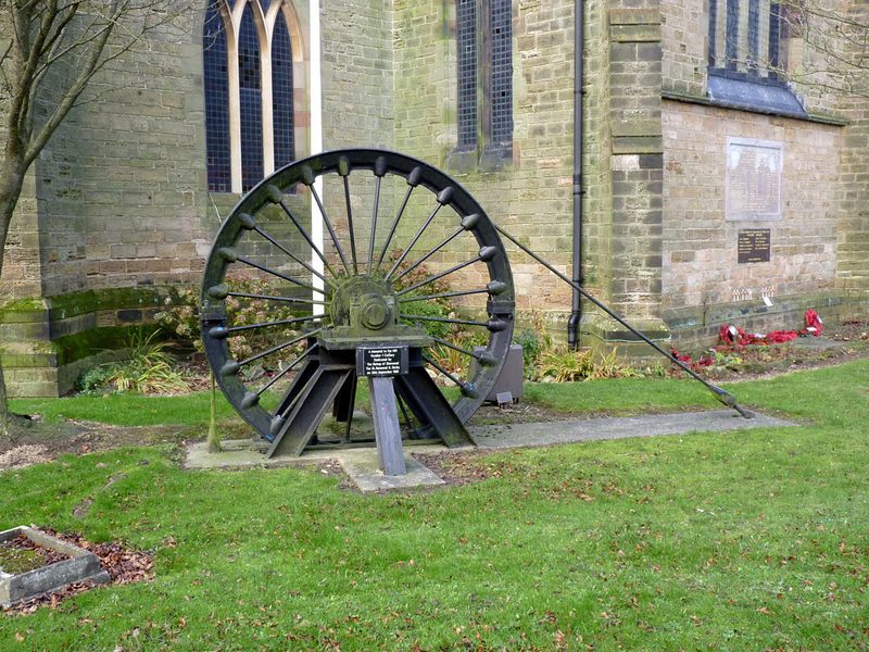 A stone memorial to the colliery standing in a churchyard
