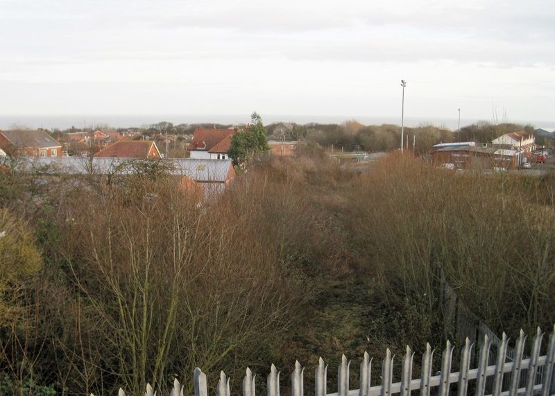 An overgrown railway cutting runs downhill between houses towards the sea at Seaham.