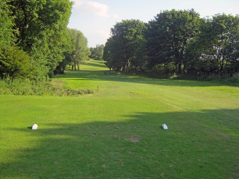 A fairway between tall trees on the golf course laid out over the old colliery tip at Shirland.