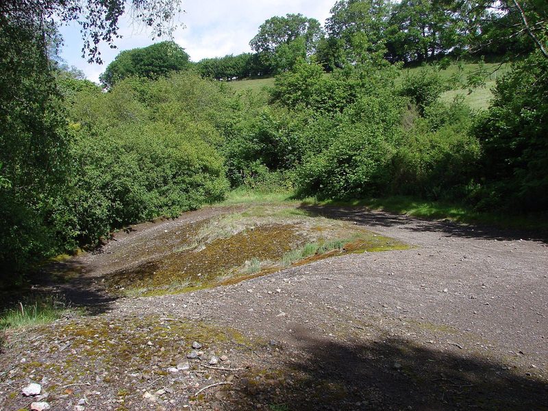 The spread of spoil in front of the ruined mine buildings at Silverbrook Mine, with the site of the sorting shed in the foreground.