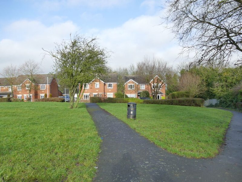 Modern brick houses around a grassed footpath in Hanbury Gardens, Garforth, on the site of the Sisters Pit shaft and colliery buildings.