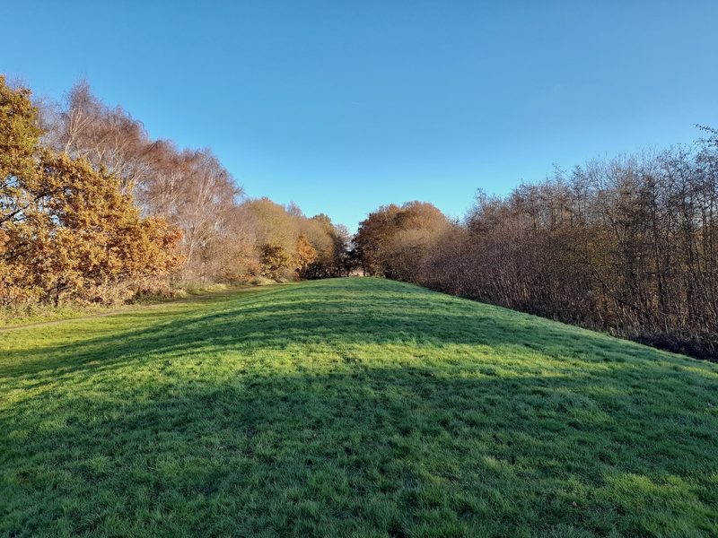 A grassy embankment and level strip marking where colliery railway sidings once ran
