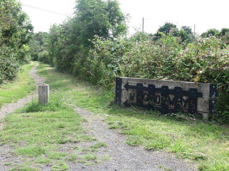 A grassy track between hedges with a wooden sign reading Waggonways, on the course of the old colliery line.