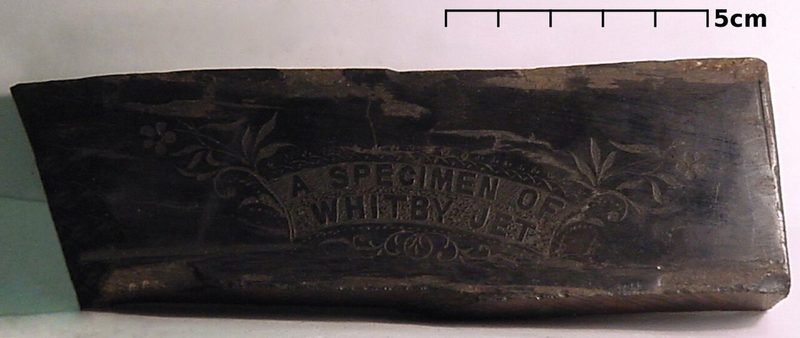 A specimen of Whitby jet, collected around 1895, shown here with a US quarter for scale.
