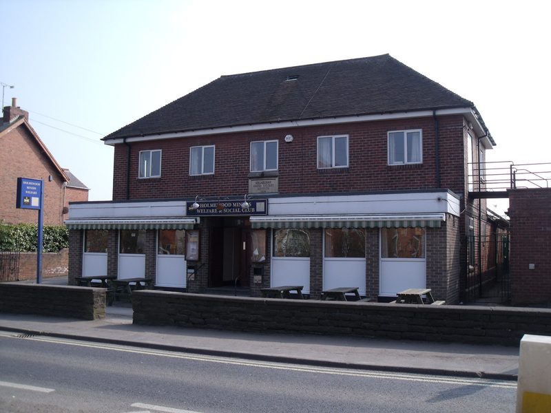 A brick miners welfare building with a car park, in a former colliery village