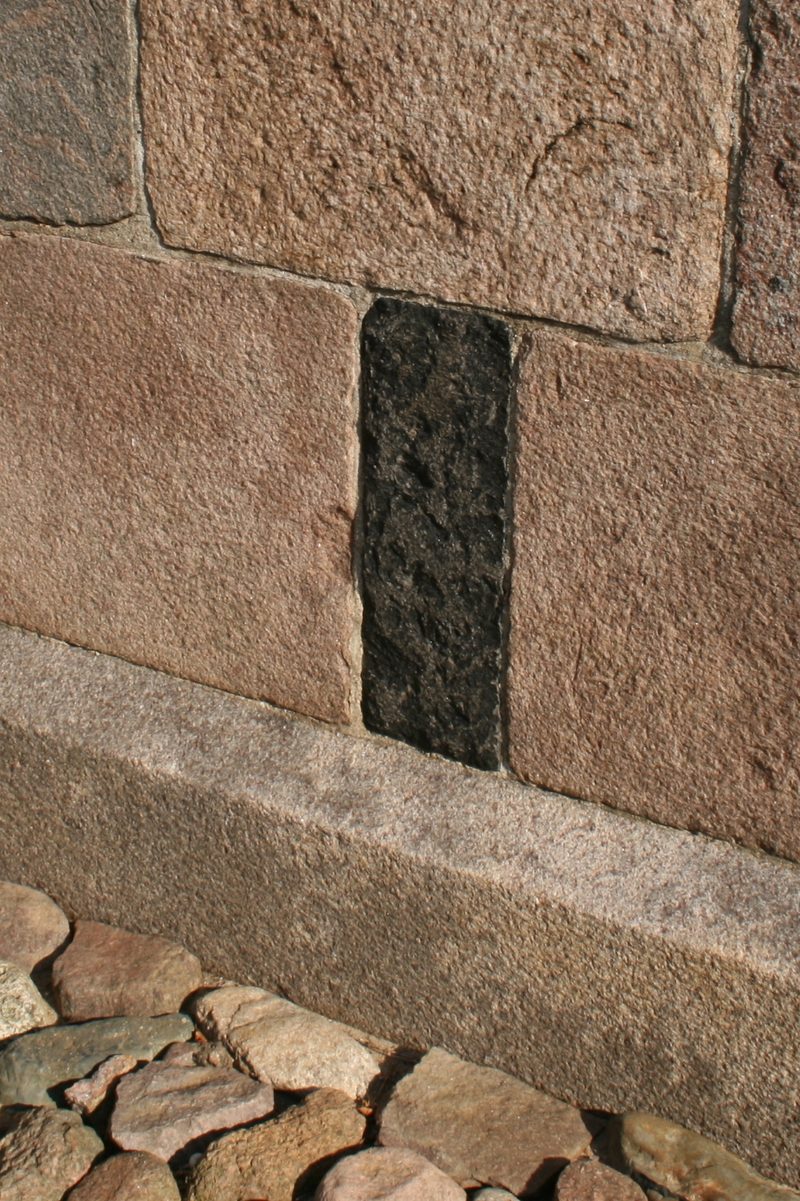 A wall of squared, smooth-faced stone blocks laid in courses with very thin mortar joints.
