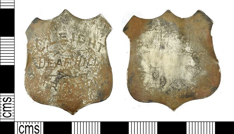 A small decorated silver mount, recovered as an archaeological find, from the end of the yardstick carried by a colliery deputy as the badge of his office.